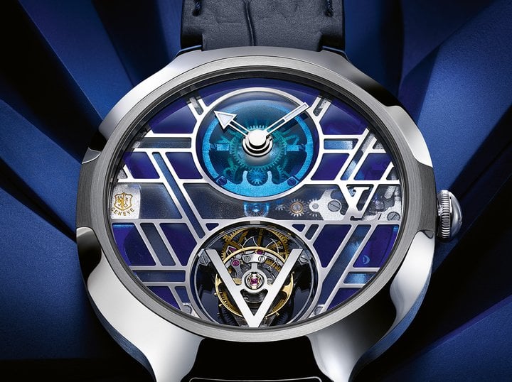 Voyager Flying Tourbillon Poinçon de Genève Plique-à-Jour: Plique-à-jour is a technique inherited from the Byzantine Empire, which few European artisans master. It consists of depositing the enamel in cavities without a backing, like a miniature piece of stained glass. The stained-glass windows of the Louis Vuitton building in Asnières served as the inspiration for this watch. Three shades of blue were used for the colour grading: ultramarine, azure and blueish grey. The gears are assembled in-line, leaving the sides free and ensuring complete transparency, despite the watch's 168 parts – an achievement the quality and complexity of which whose quality and complexity earned it the Geneva Seal. 