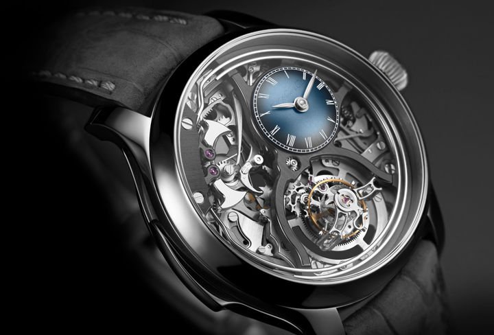 Endeavour Minute Repeater Cylindrical Tourbillon Skeleton: a fully skeletonised minute repeater, with its mechanism on full display, combined with a flying tourbillon fitted with a cylindrical balance spring. Two pinnacles of traditional watchmaking brought together in a single timepiece with a resolutely contemporary design, housed within a 40 mm diameter titanium case. At 2 o'clock, a small domed dial, featuring H. Moser & Cie.'s famous smoked Funky Blue, acts as a secret signature.