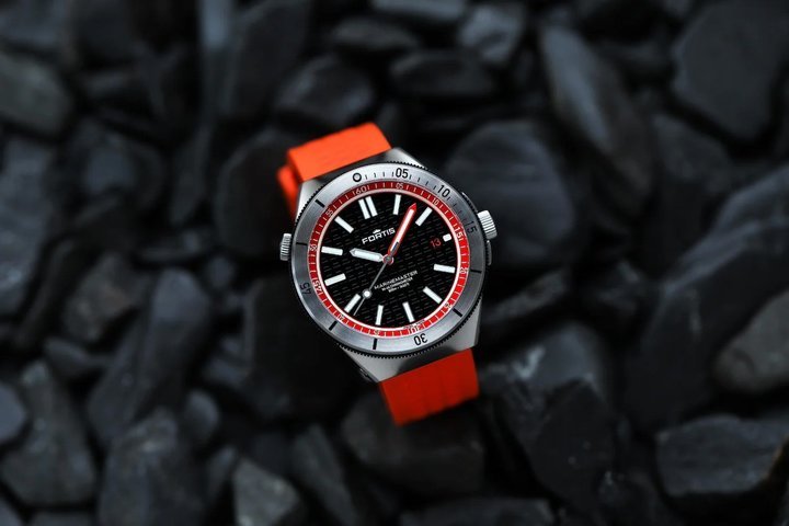 The Marinemaster M-44, shown here in Amber Orange, features applied hands, indexes and logo filled with X1 Super-LumiNova and a bidirectional Gear Bezel™. The movement is the COSC-certified Kenissi Werk 11.